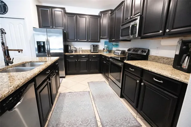 a kitchen with stainless steel appliances granite countertop a stove refrigerator sink and cabinets