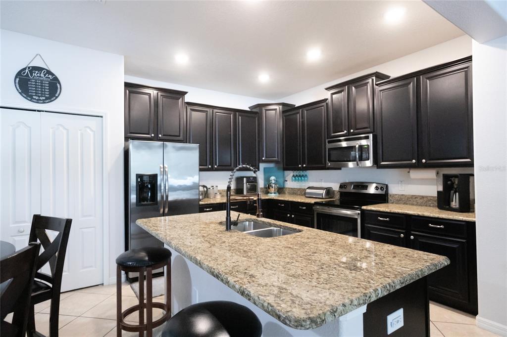 1185 Seburn Road Apopka, FL 32703 - Photo 19 of 47 a kitchen with stainless steel appliances granite countertop a stove refrigerator sink and cabinets