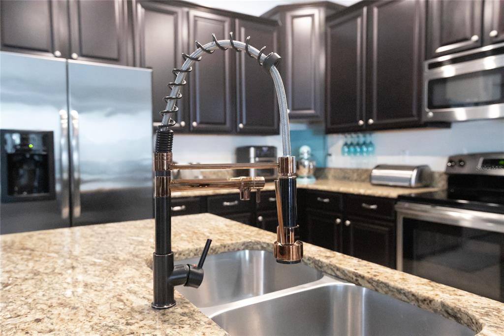 1185 Seburn Road Apopka, FL 32703 - Photo 20 of 47 a kitchen with stainless steel appliances kitchen island granite countertop a refrigerator a stove and a sink with wooden floor