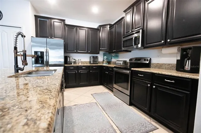 a kitchen with granite countertop a sink and a stove top oven