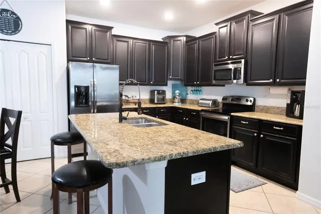a kitchen with stainless steel appliances granite countertop a stove refrigerator sink and cabinets
