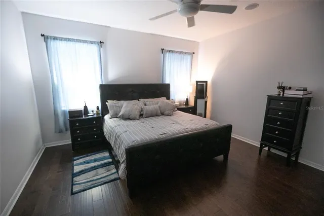 a bedroom with a bed and a chandelier fan