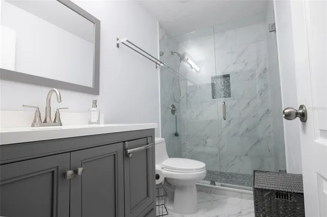 a bathroom with a sink a toilet and shower