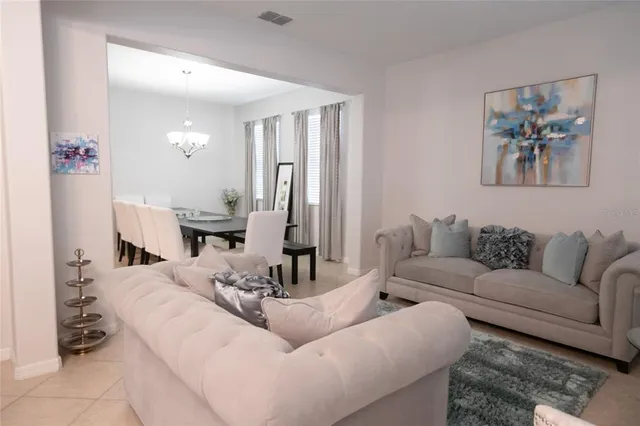 a living room with furniture and a painting on the wall