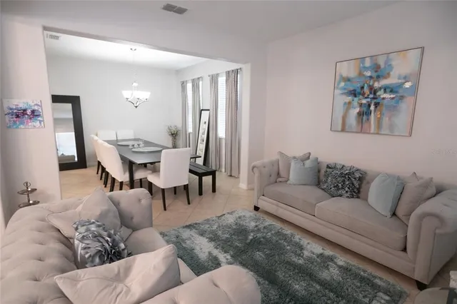 a living room with furniture and a dining table