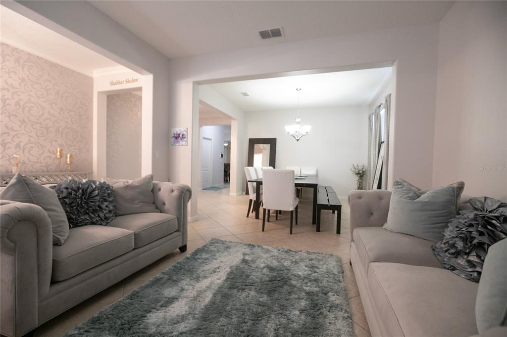 1185 Seburn Road Apopka, FL 32703 - Photo 7 of 47 a living room with furniture and a dining table