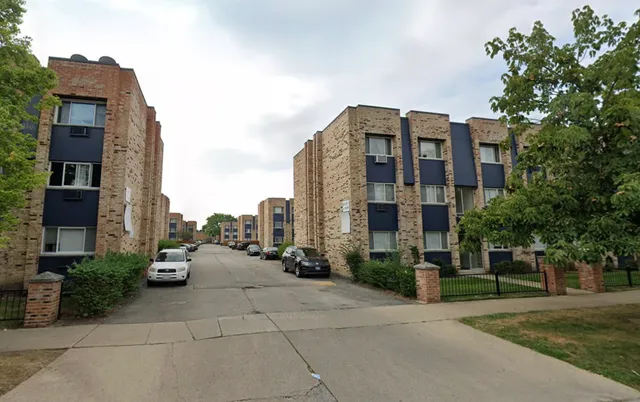 a view of a tall building next to a yard