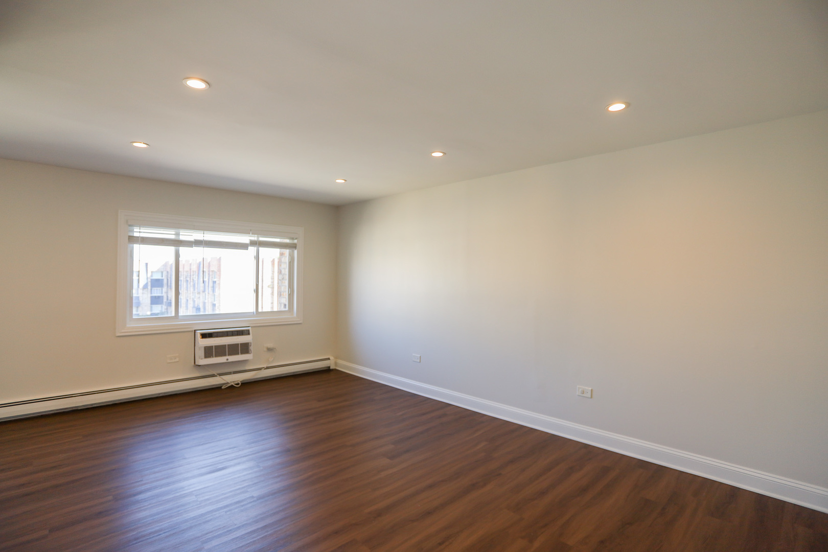 8651 West Foster Avenue, Unit 3A Chicago, IL 60656 - Photo 13 of 17 an empty room with wooden floor and windows
