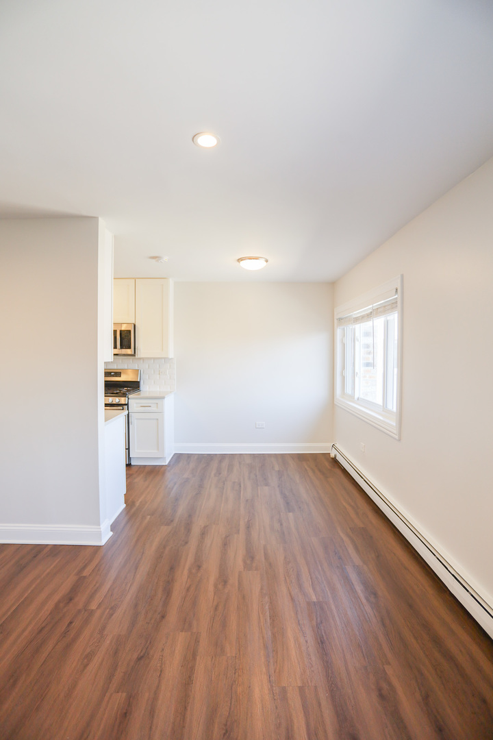 8651 West Foster Avenue, Unit 3A Chicago, IL 60656 - Photo 14 of 17 wooden floor in an empty room with a window