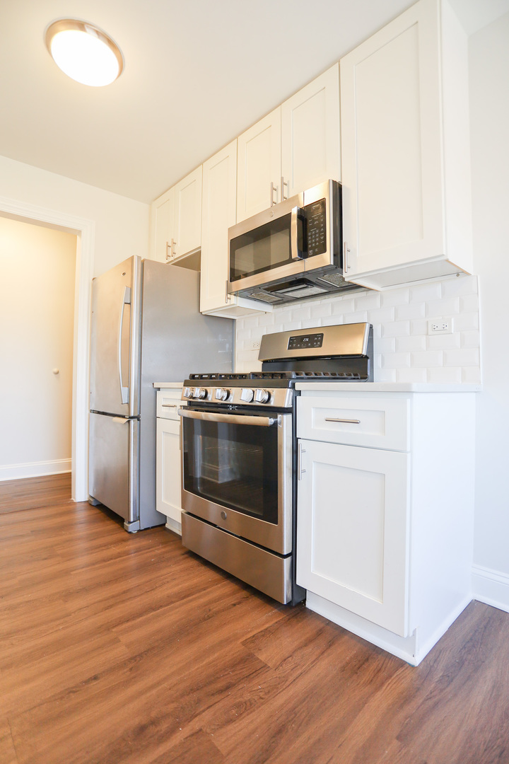 8651 West Foster Avenue, Unit 3A Chicago, IL 60656 - Photo 2 of 17 a kitchen with stainless steel appliances a stove a microwave and a refrigerator