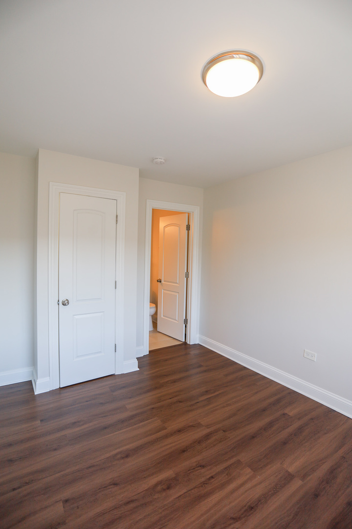 8651 West Foster Avenue, Unit 3A Chicago, IL 60656 - Photo 8 of 17 a view of an empty room with wooden floor and a window
