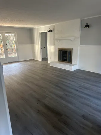 an empty room with wooden floor and fireplace
