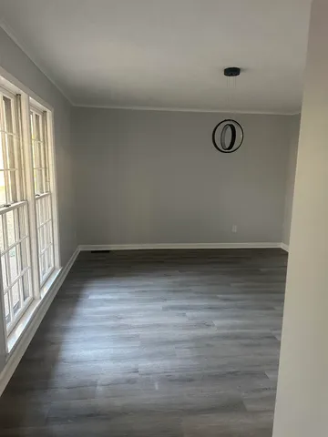 a view of a room with wooden floor and window