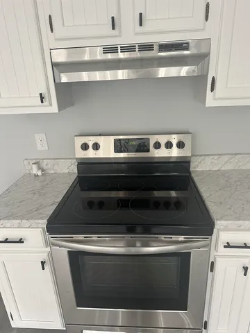 a stove top oven sitting inside of a kitchen