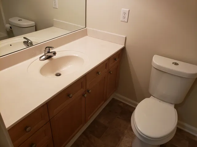 a bathroom with a sink a toilet and mirror