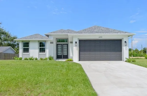 a front view of a house with a yard and garage