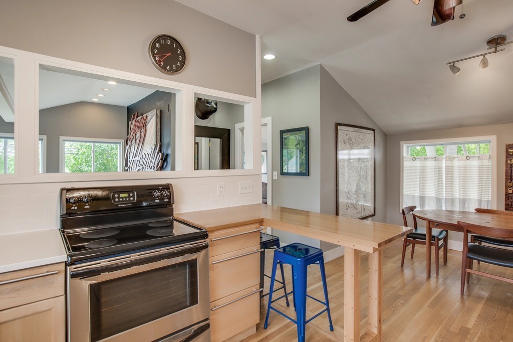 93 Hardy Pond Road Waltham, MA 02451 - Photo 8 of 29 a kitchen with a stove a refrigerator and a dining table with wooden floor