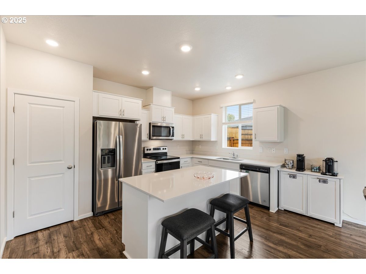 3499 Southeast Paropa Avenue Gresham, OR 97080 - Photo 19 of 48 a kitchen with stainless steel appliances a sink a stove a refrigerator cabinets and a dining table