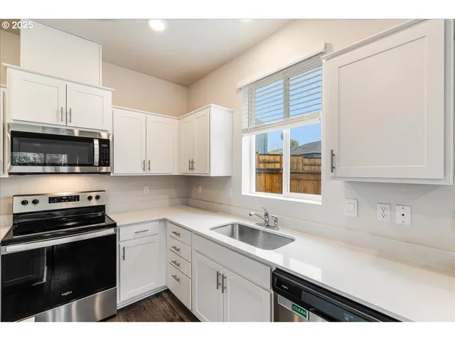 a kitchen with stainless steel appliances a refrigerator a stove a microwave and cabinets