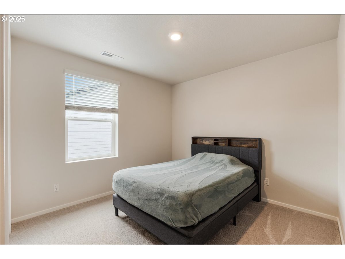 3499 Southeast Paropa Avenue Gresham, OR 97080 - Photo 31 of 48 a bedroom with a bed window and a night stand