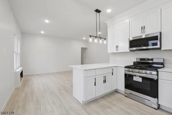 a kitchen with stainless steel appliances a stove top oven a sink and cabinets