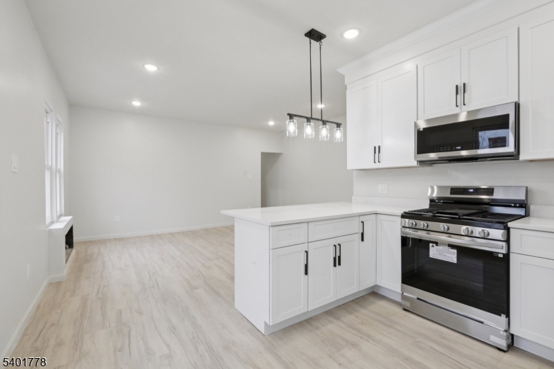 a kitchen with stainless steel appliances a stove top oven a sink and cabinets
