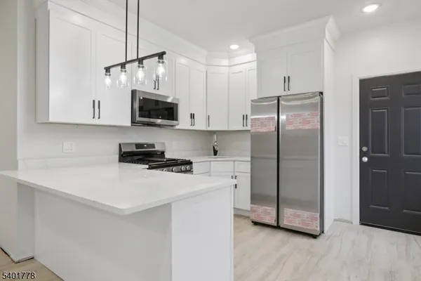 a kitchen with stainless steel appliances a refrigerator sink and microwave