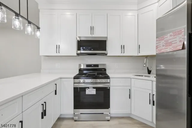 a kitchen with white cabinets stainless steel appliances and sink