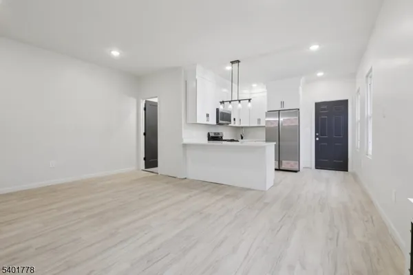 a kitchen with stainless steel appliances kitchen island a refrigerator sink and cabinets