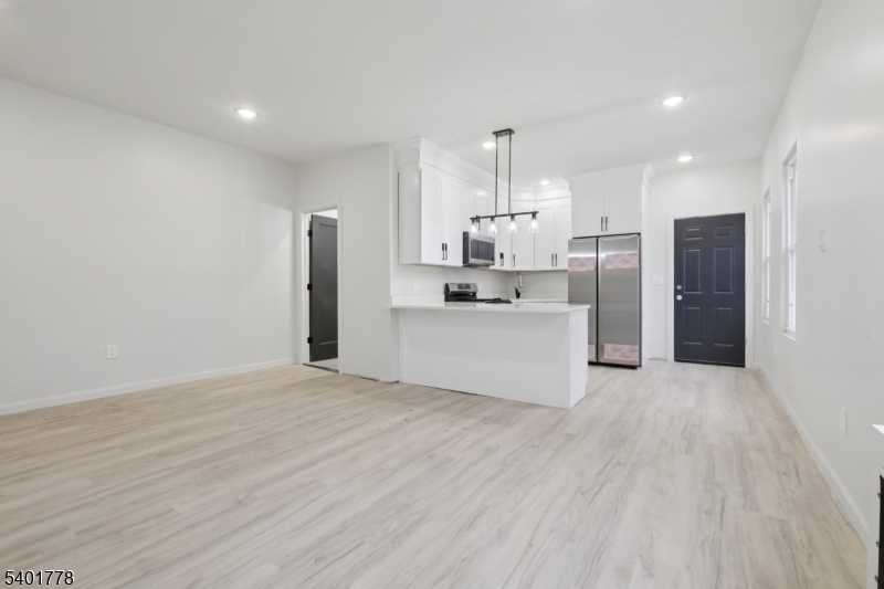 540 East 25th Street Paterson, NJ 07514 - Photo 4 of 10 a kitchen with stainless steel appliances kitchen island a refrigerator sink and cabinets