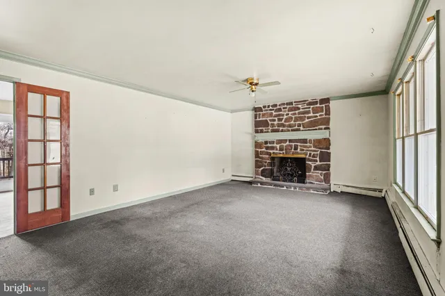 an empty room with a fireplace and window