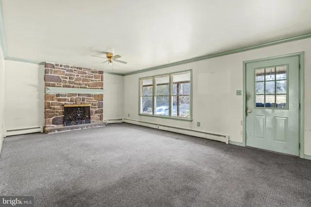 an empty room with fireplace and windows