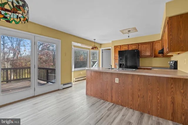 a kitchen with stainless steel appliances granite countertop a stove a sink and a refrigerator with wooden floor