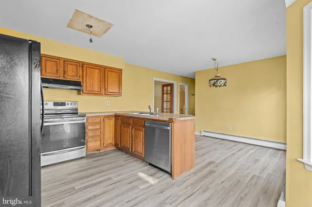 a kitchen with a refrigerator and a stove top oven