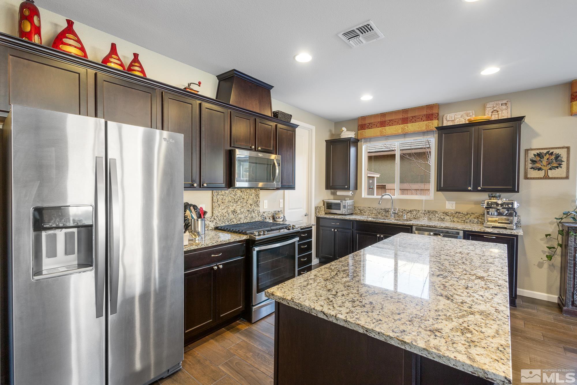 2875 Bonfire Lane Reno, NV 89521 - Photo 10 of 39 a kitchen with stainless steel appliances granite countertop a refrigerator a stove and a sink