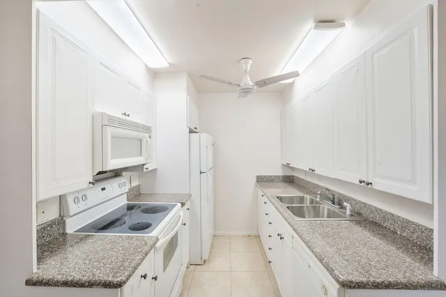 a kitchen with stainless steel appliances granite countertop a sink and a refrigerator