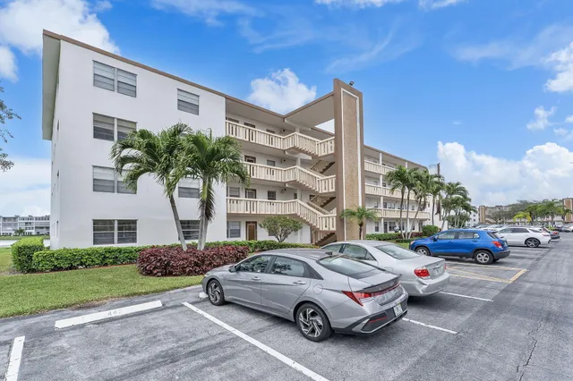 a view of a patio with couches and a table and chairs with wooden floor and fence