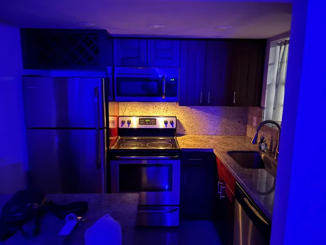 a kitchen with a sink a stove cabinets and a chair