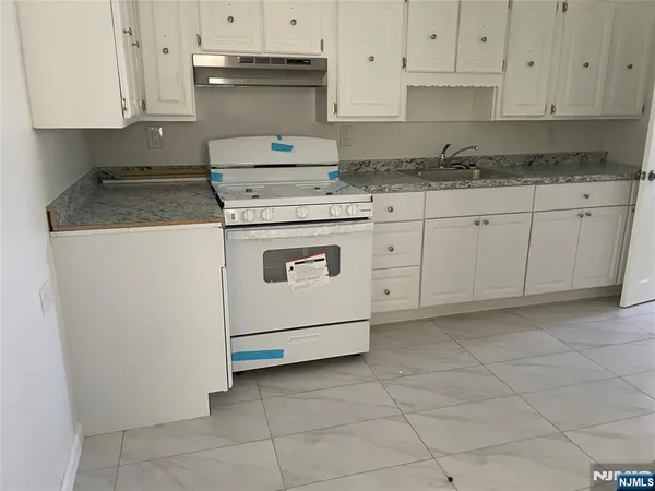 a kitchen with granite countertop white cabinets and white appliances