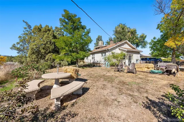 a view of a house with backyard and sitting area