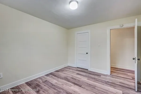 a view of a room with wooden floor and white doors
