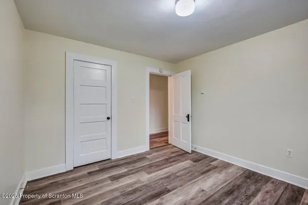 a view of a livingroom with wooden floor and bathroom
