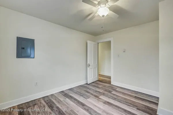 a view of a room with wooden floor and a ceiling fan