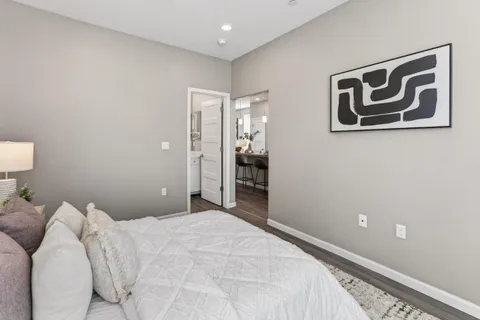 a bedroom with a large bed and a potted plant