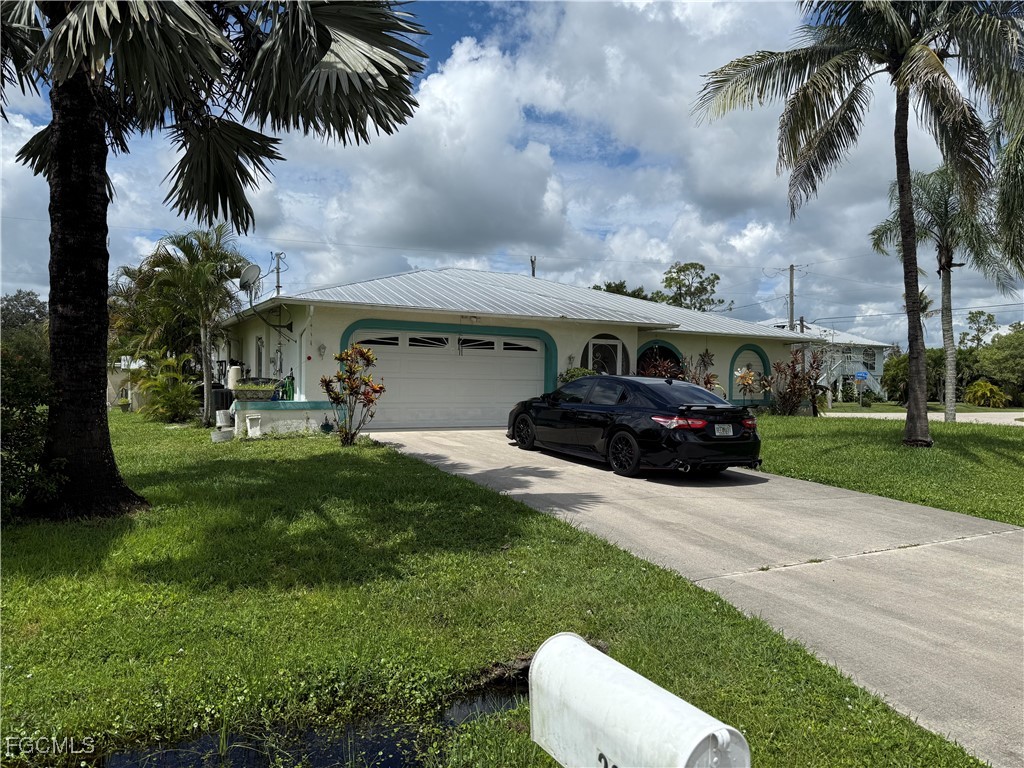 2260 Thompson Road Alva, FL 33920 - Photo 2 of 13 a front view of a house with garden and trees