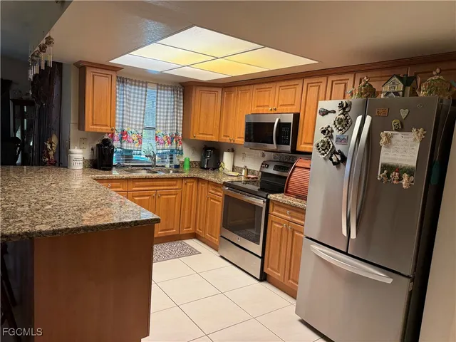 a kitchen with stainless steel appliances granite countertop a refrigerator a stove and a sink