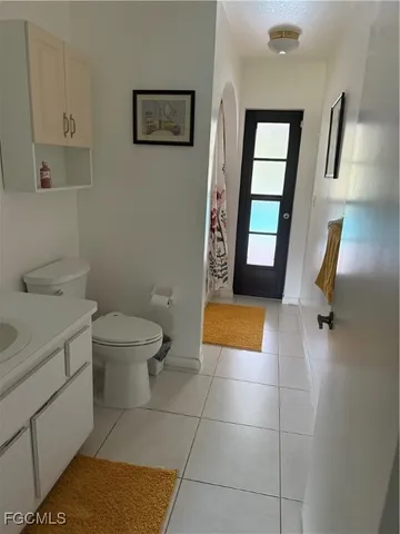 a bathroom with a toilet a sink a mirror and shower