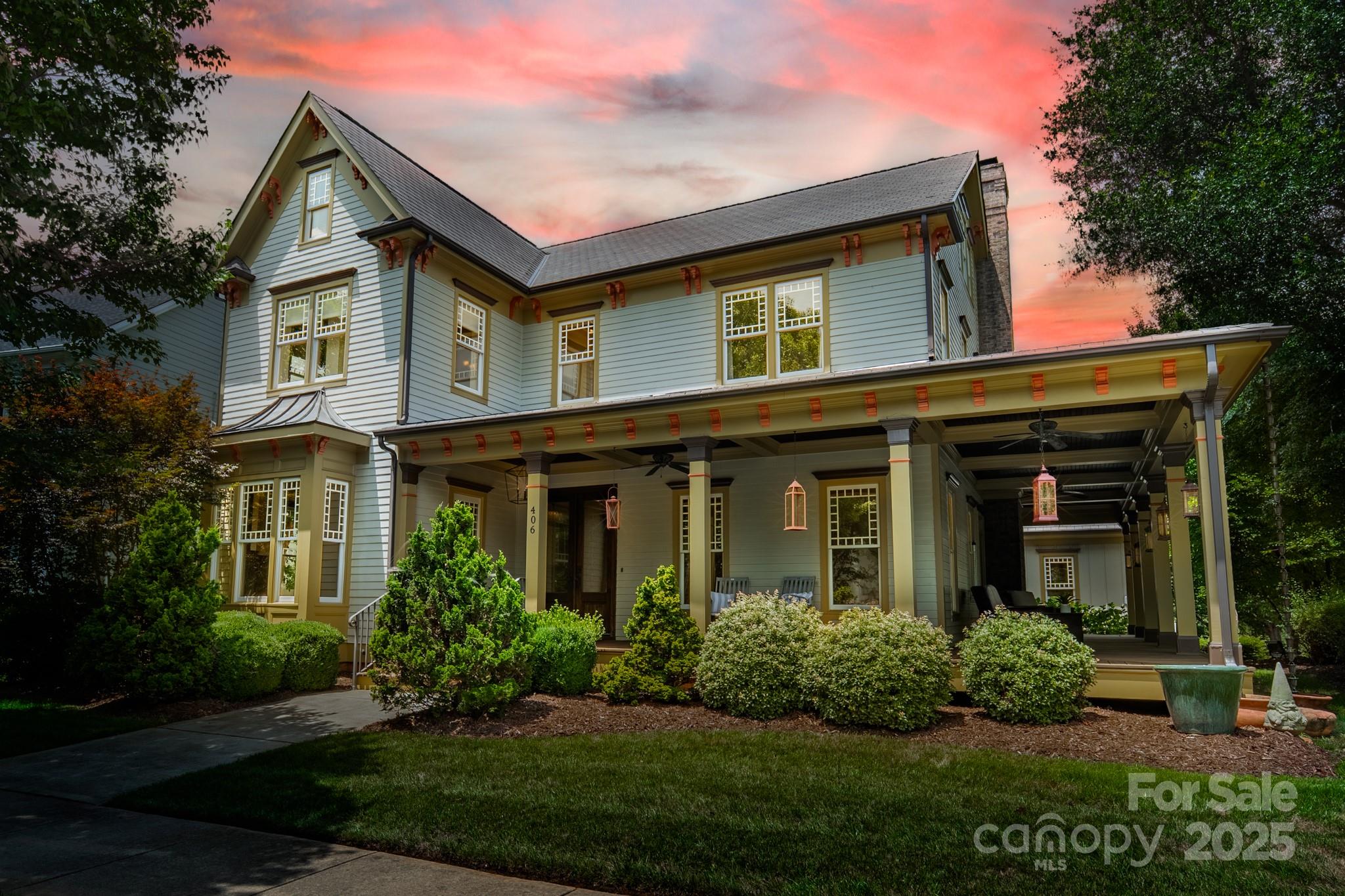 a front view of a house with a yard and potted plants