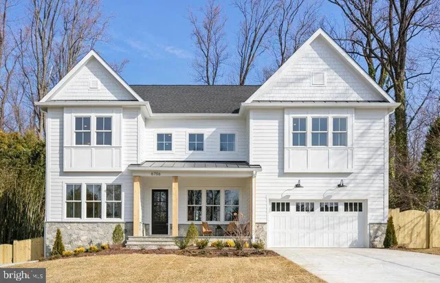 a view of a white house with large windows and a tree