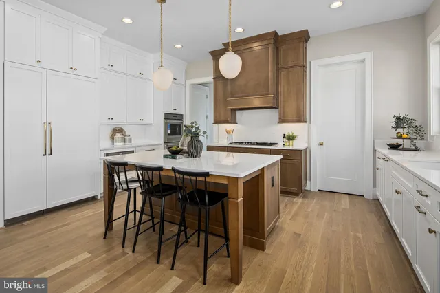 a kitchen with a sink stove and wooden floor